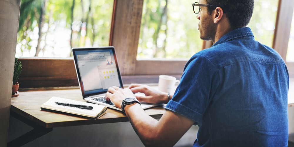 A man types on a laptop while strategizing how to develop informative website content